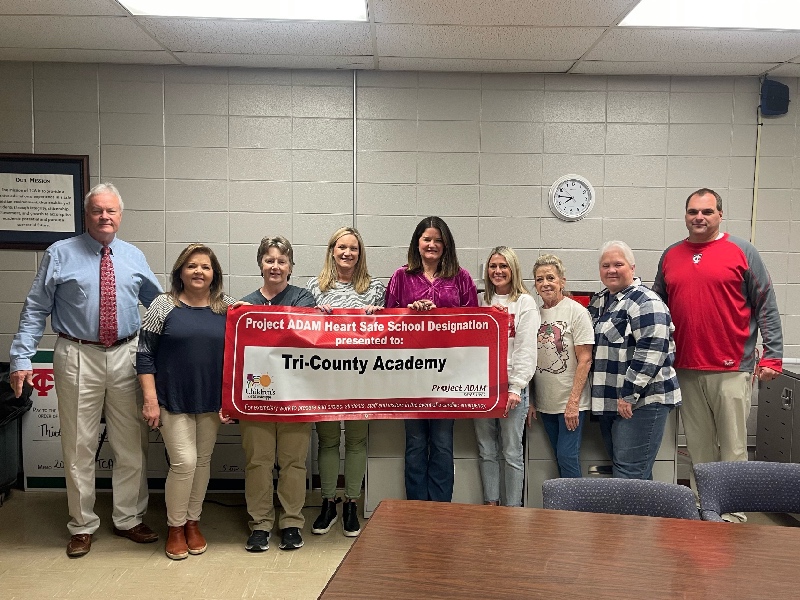 Group photo of Tri County Academy holding banner with HeartSafe School designation